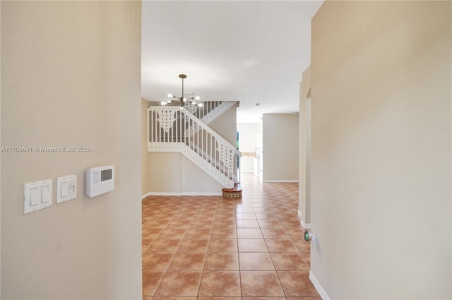 hall with light tile patterned floors and an inviting chandelier