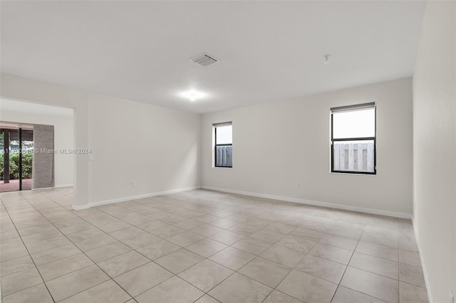 spare room featuring light tile patterned floors and plenty of natural light