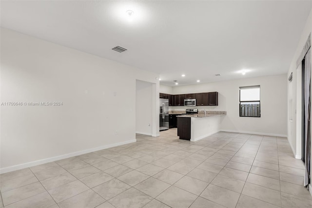 kitchen with kitchen peninsula, light tile patterned floors, stainless steel appliances, and sink