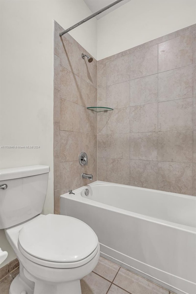 bathroom featuring tile patterned floors, tiled shower / bath combo, and toilet