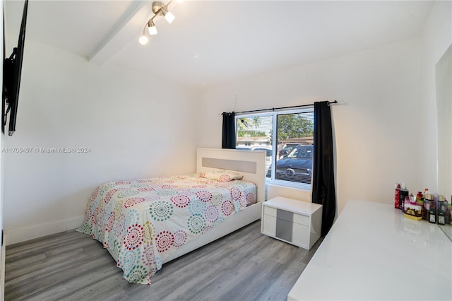 bedroom with beam ceiling and light hardwood / wood-style floors