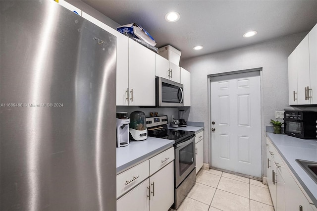 kitchen with white cabinetry, light tile patterned flooring, and appliances with stainless steel finishes