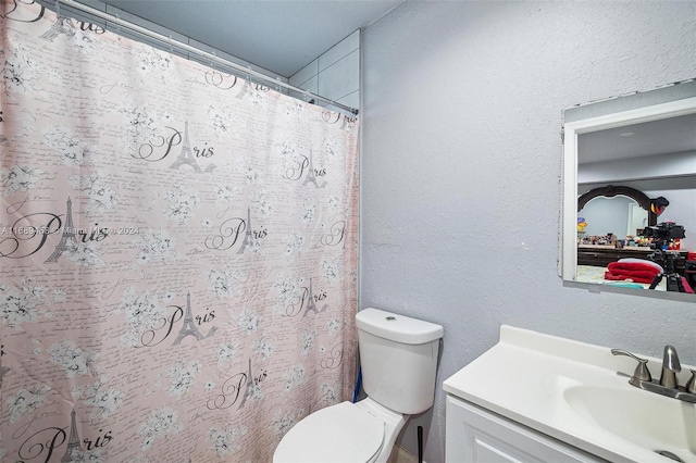 bathroom featuring a shower with shower curtain, vanity, and toilet