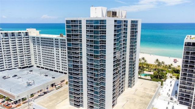 view of property with a water view and a beach view