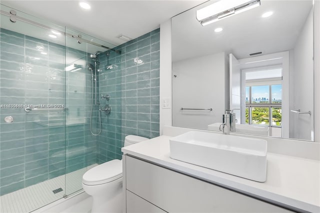 bathroom with vanity, toilet, and a shower with shower door