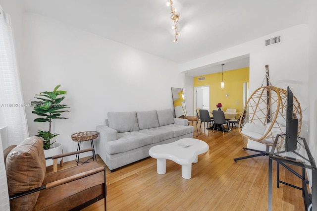 living room featuring light wood-style flooring and visible vents