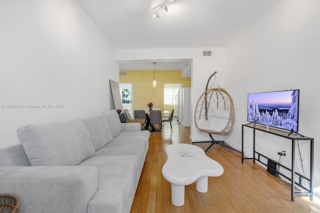 living room with rail lighting and wood-type flooring