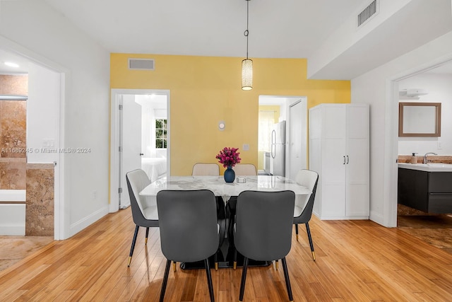 dining space with light hardwood / wood-style flooring and sink