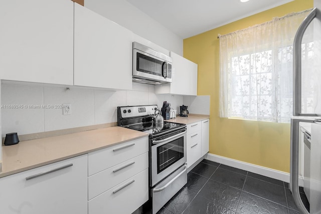 kitchen featuring white cabinets, stainless steel appliances, and tasteful backsplash