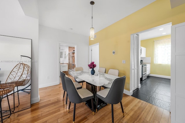 dining room with baseboards and hardwood / wood-style floors