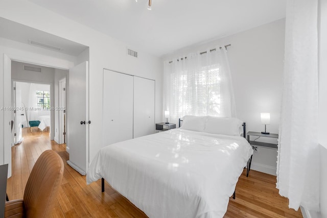 bedroom with visible vents, a closet, and light wood-type flooring