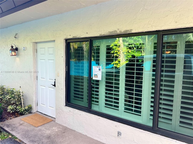 doorway to property with stucco siding