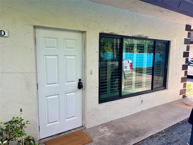 entrance to property featuring stucco siding