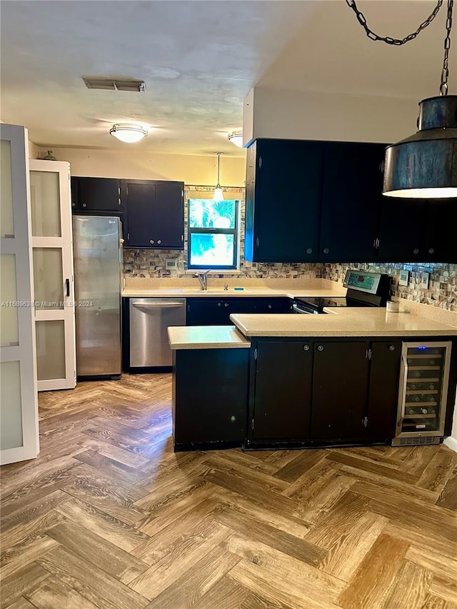 kitchen with wine cooler, light parquet floors, decorative light fixtures, and appliances with stainless steel finishes