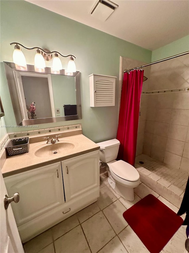 bathroom featuring tile patterned flooring, toilet, vanity, and walk in shower