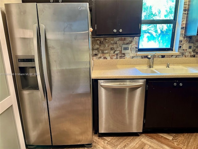 kitchen featuring decorative backsplash, sink, light parquet floors, and stainless steel appliances