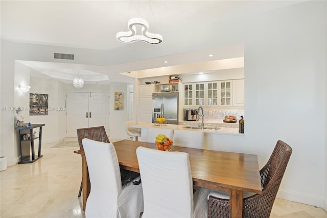 dining area with a tray ceiling and sink