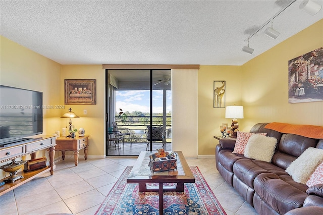 tiled living room featuring floor to ceiling windows, track lighting, and a textured ceiling