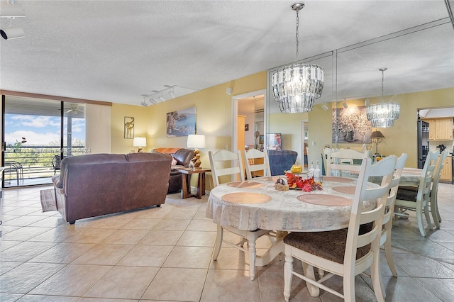 dining space featuring a textured ceiling, track lighting, and light tile patterned flooring