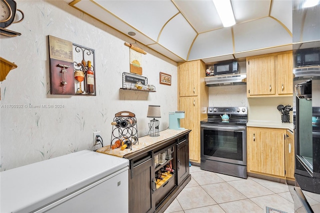 kitchen featuring stainless steel electric stove, lofted ceiling, and light tile patterned flooring