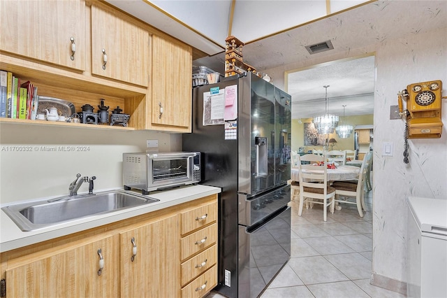 kitchen with sink, black refrigerator with ice dispenser, pendant lighting, light brown cabinetry, and light tile patterned flooring