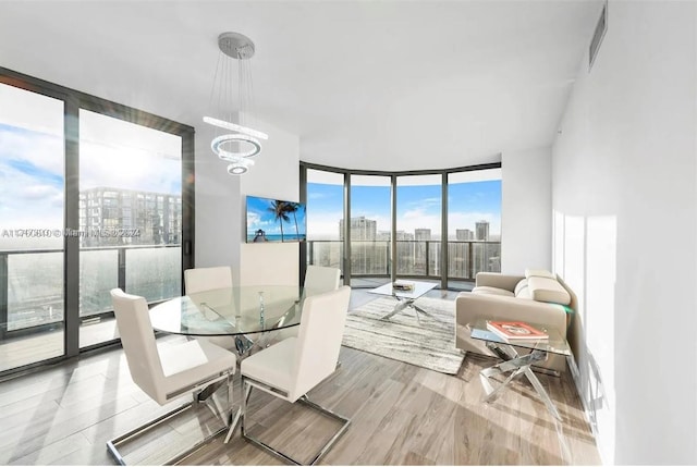 801 S Miami Ave Unit 4509, Miami, FL 33130 - dining space featuring an inviting chandelier, expansive windows, and hardwood / wood-style flooring