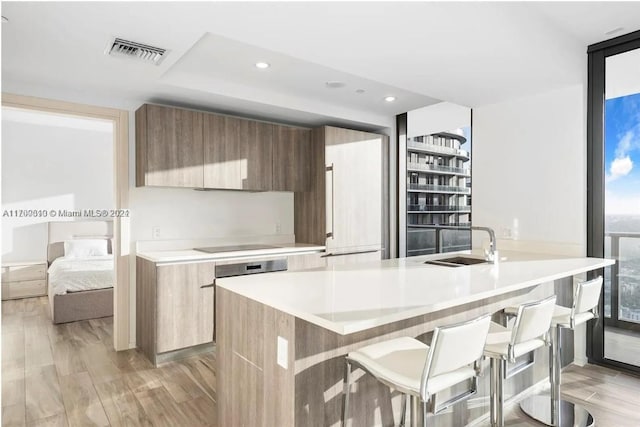 kitchen featuring light wood-type flooring, sink, and a breakfast bar area