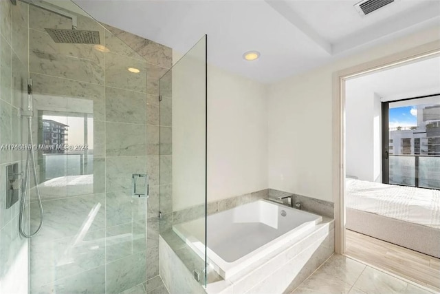 bathroom featuring hardwood / wood-style flooring, plenty of natural light, and independent shower and bath