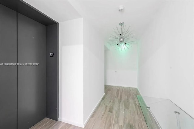 corridor with elevator and light wood-type flooring