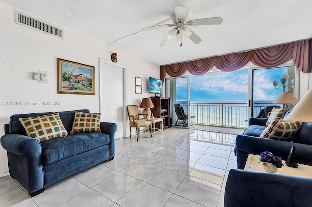 tiled living room featuring ceiling fan and a textured ceiling