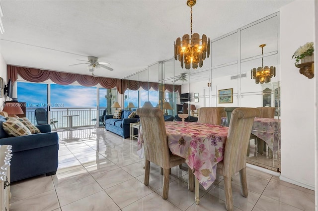 tiled dining area featuring a textured ceiling and ceiling fan with notable chandelier