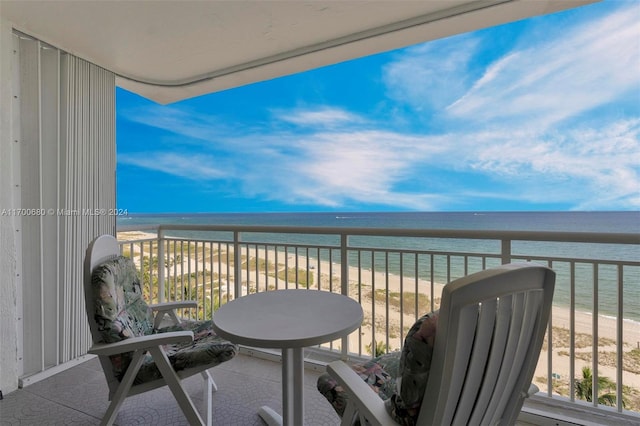 balcony with a water view and a view of the beach