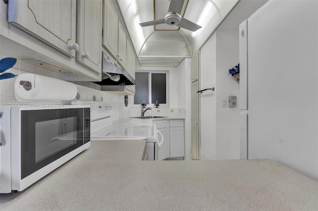 kitchen with decorative backsplash, white appliances, and sink