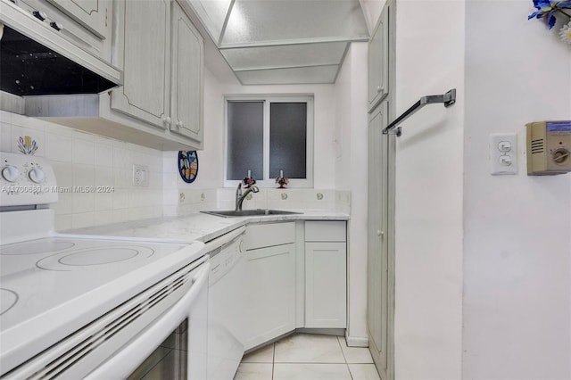 kitchen with backsplash, light tile patterned flooring, white appliances, and sink