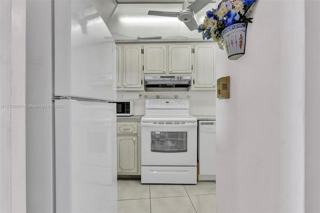 kitchen featuring light tile patterned flooring, white appliances, and cream cabinetry