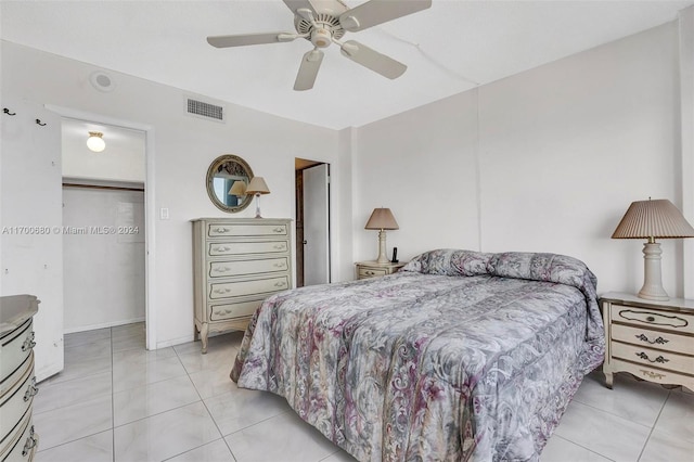 bedroom with ceiling fan, light tile patterned flooring, and a closet