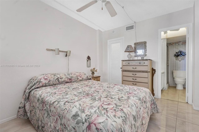 bedroom featuring ceiling fan, light tile patterned floors, and ensuite bath