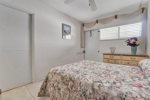 tiled bedroom featuring ceiling fan