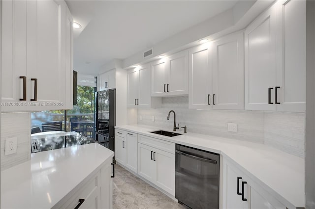 kitchen featuring tasteful backsplash, white cabinetry, sink, and black appliances