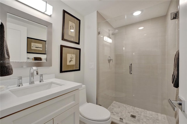 bathroom with vanity, toilet, and a shower with door