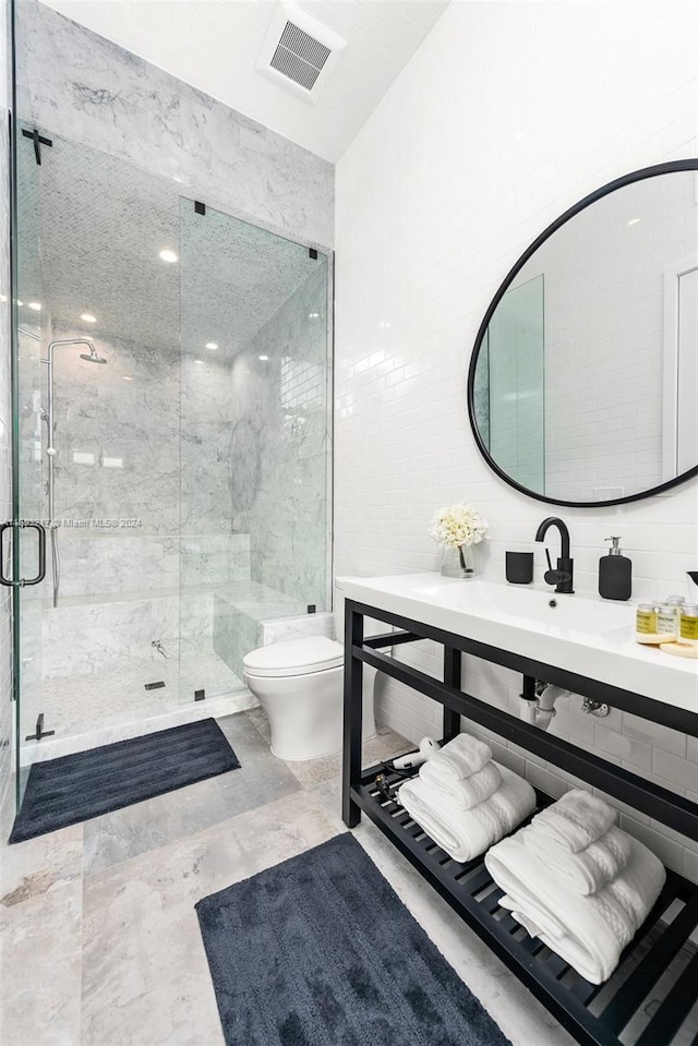 bathroom featuring walk in shower, vanity, tile walls, and toilet