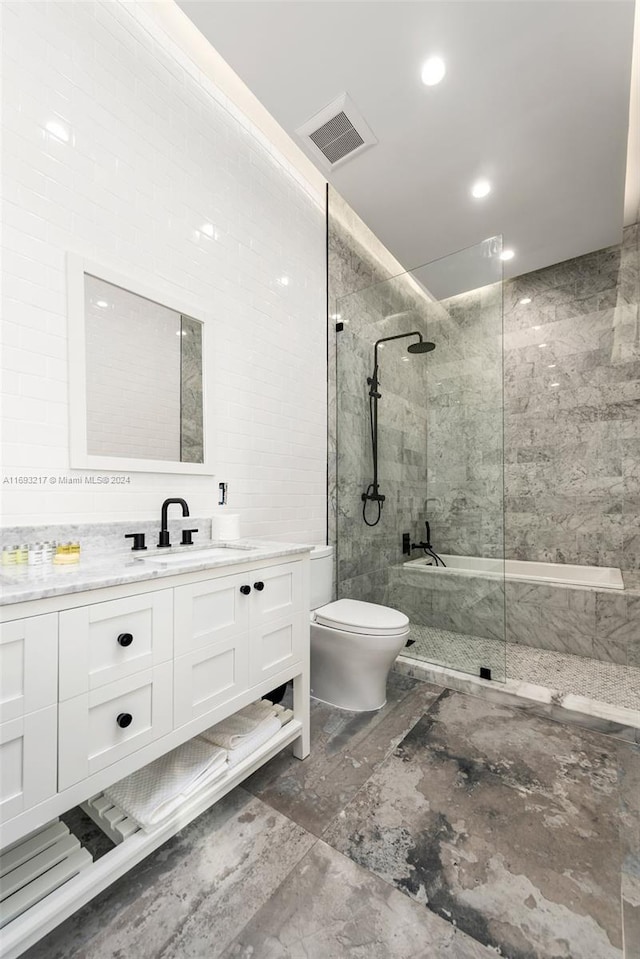 bathroom featuring tiled shower, vanity, and toilet