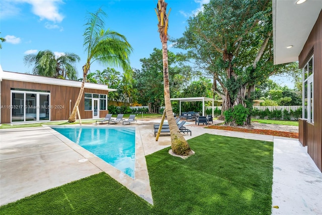 view of swimming pool with a yard and a patio