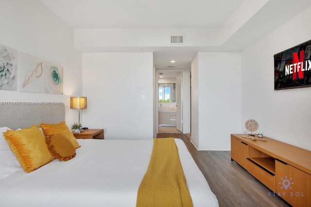 bedroom featuring light wood-type flooring and connected bathroom