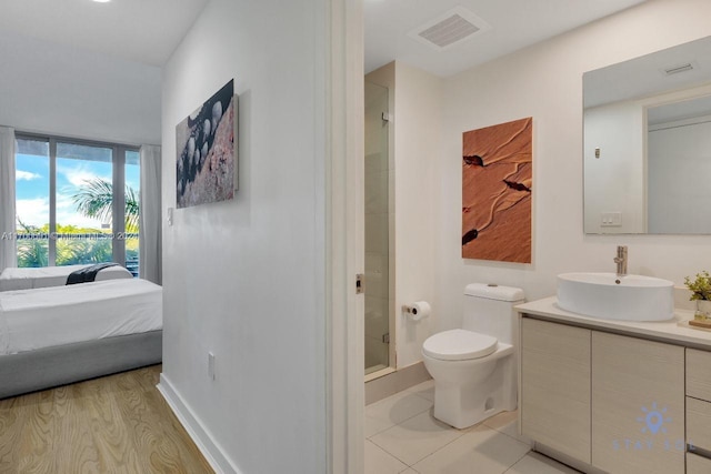 bathroom with vanity, hardwood / wood-style flooring, toilet, and a shower with shower door