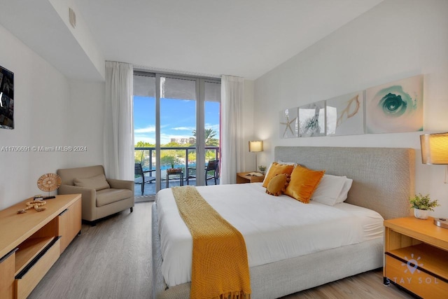 bedroom with access to exterior, floor to ceiling windows, and light hardwood / wood-style floors