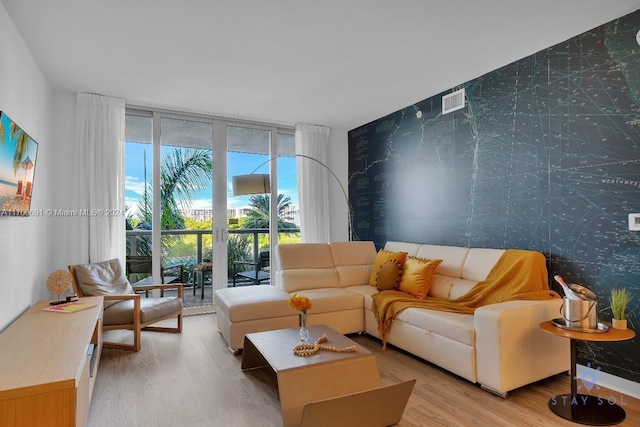 living room featuring floor to ceiling windows and light hardwood / wood-style flooring