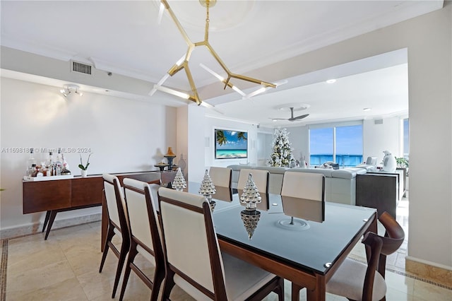 tiled dining room with ceiling fan with notable chandelier and ornamental molding