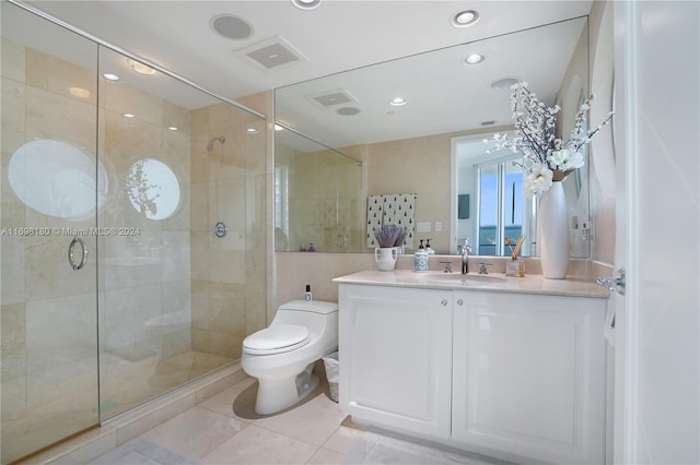 bathroom featuring toilet, vanity, tile patterned floors, and an enclosed shower