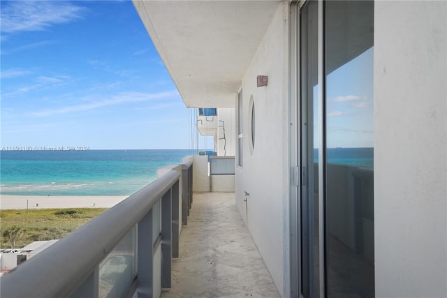 balcony featuring a water view and a view of the beach